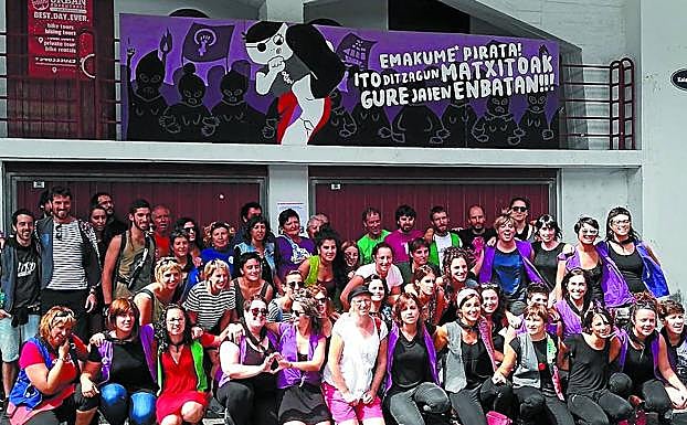 Representantes de todas las cofradrías posan frente al mural que denuncia las agresiones sexistas.