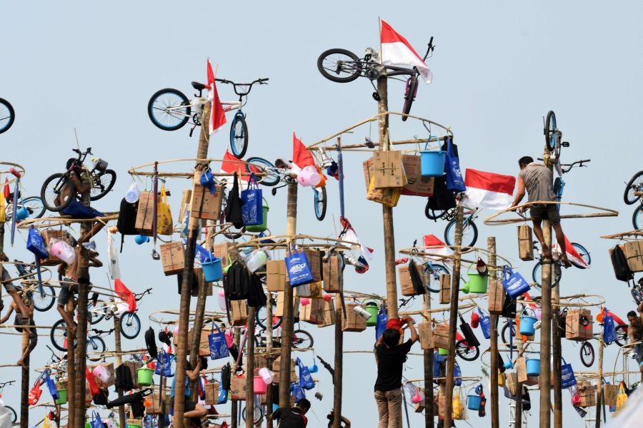 Indonesia celebra su 72 aniversario de independencia y por ello, a lo largo del territorio, se celebra la tradicional 'Panjat Pinang'. En una explanada se colocan arboles tallados, previamente lubricados con regalos en la parte más alta y los nativos deben alcanzar la cima para conseguir los presentes.