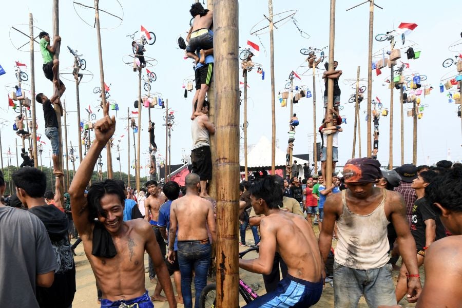 Indonesia celebra su 72 aniversario de independencia y por ello, a lo largo del territorio, se celebra la tradicional 'Panjat Pinang'. En una explanada se colocan arboles tallados, previamente lubricados con regalos en la parte más alta y los nativos deben alcanzar la cima para conseguir los presentes.