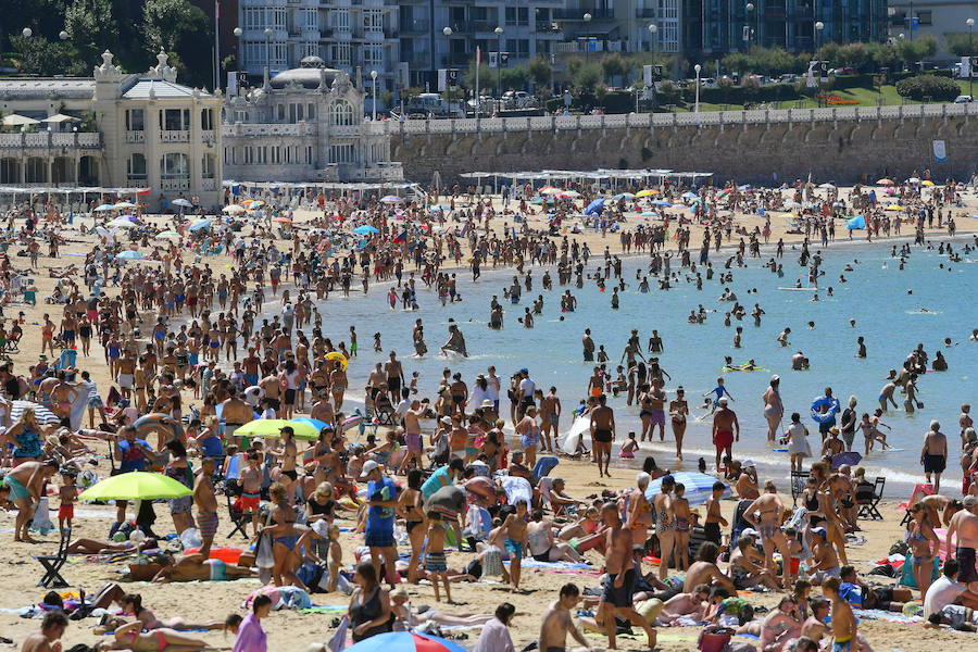 El fuerte calor ha hecho que las playas guipuzcoanas presenten este lunes una masiva alfuencia de gente. En las imágenes, San Sebastián y Zarautz.