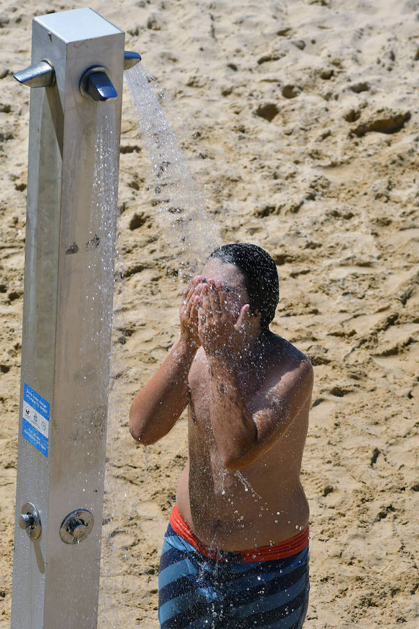 El fuerte calor ha hecho que las playas guipuzcoanas presenten este lunes una masiva alfuencia de gente. En las imágenes, San Sebastián y Zarautz.