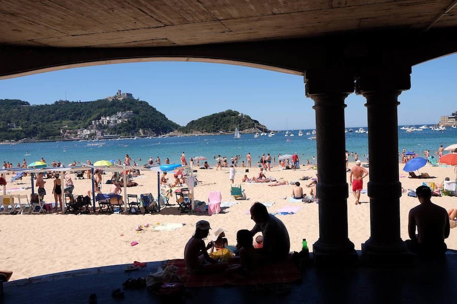 El fuerte calor ha hecho que las playas guipuzcoanas presenten este lunes una masiva alfuencia de gente. En las imágenes, San Sebastián y Zarautz.