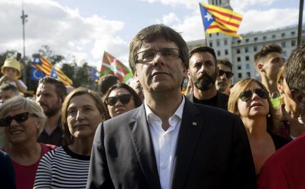 El presidente de la Generalitat de Cataluña, Carles Puigdemont (c).