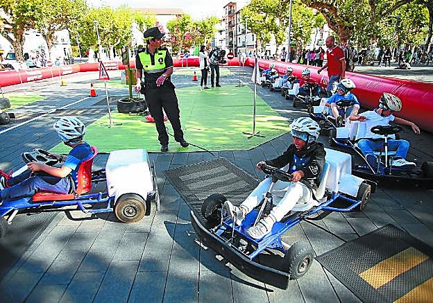 Escolares escuchan las instrucciones de un agente antes de conducir por el circuito.