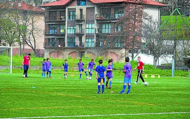 Unos niños entrenan en el campo de fútbol de Zizurkil.