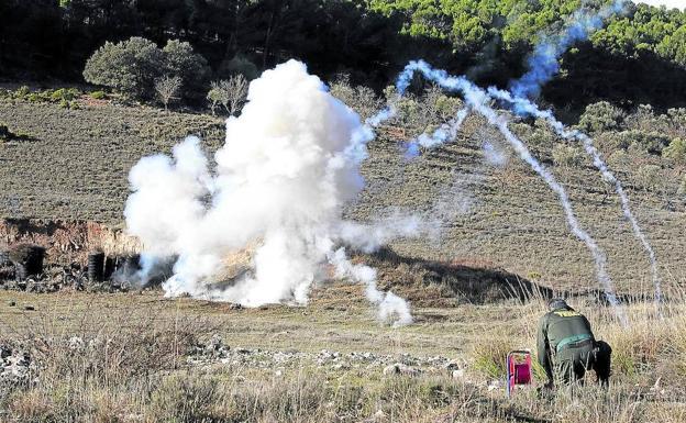 Un artificero de la Guardia Civil realiza una explosión controlada en un terreno acotado y desalojado. 