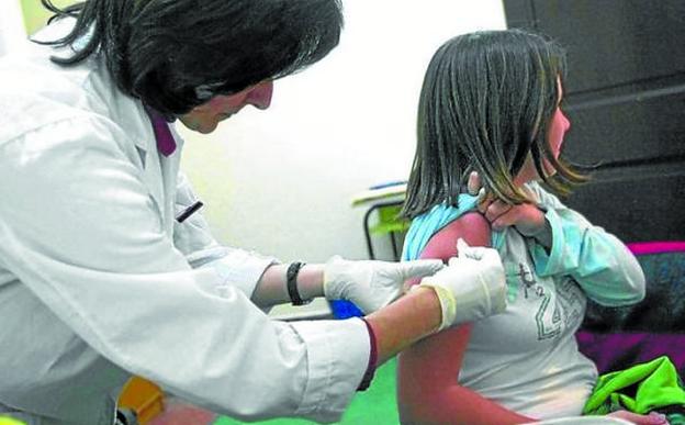 Una enfermera vacuna a una alumna de la ESO. 