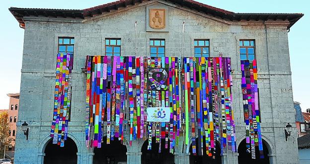 Imagen de la gran bufanda colgando en la fachada del ayuntamiento. 