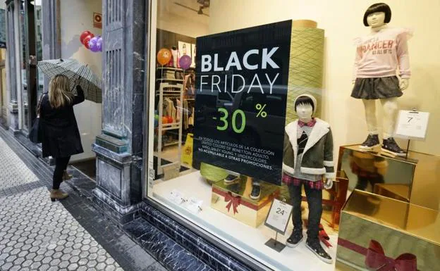 Una mujer entra en una tienda con descuentos por el 'Black Friday' en el centro de San Sebastián.