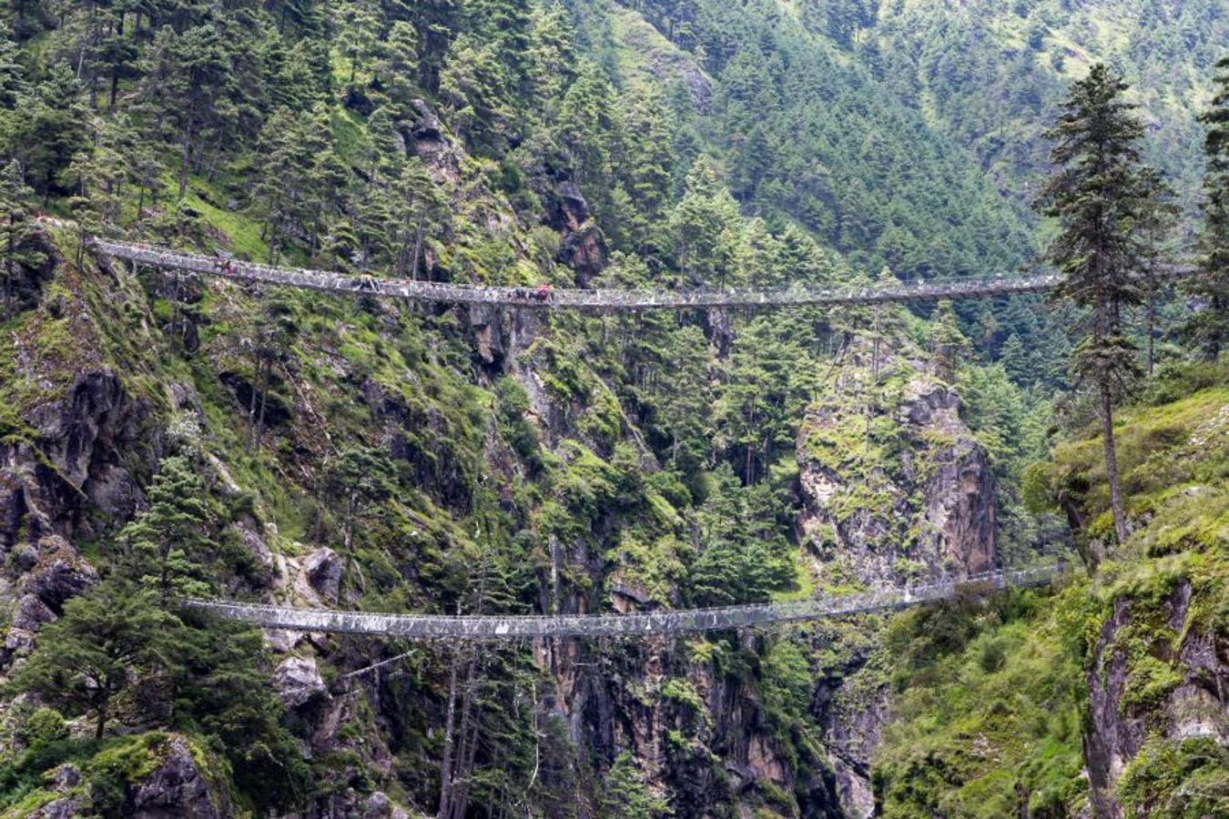 Con la segunda etapa comienza el desnivel positivo, un recorrido que finaliza con dos horas de continua subida que nos hará cruzar por varios puentes tibetanos hasta llegar a la capital de los sherpas: Namche Bazaar.