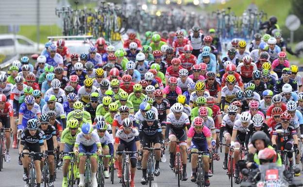 Ciclistas circulan en pelotón por las inmediaciones de Etxebarria, donde dio comienzo la primera etapa de la Vuelta al Pais Vasco 2016. 