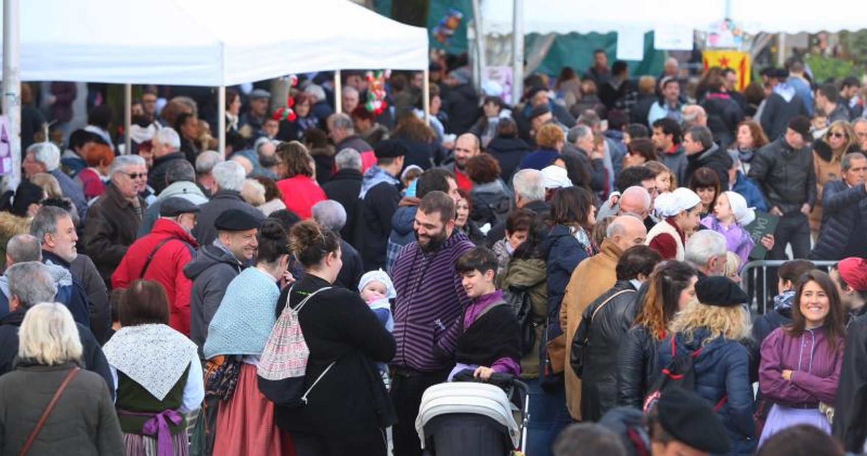 Mayores y niños disfrutan de los talos y la txistorra que se ofrecen en lo diferentes puestos de la localidad