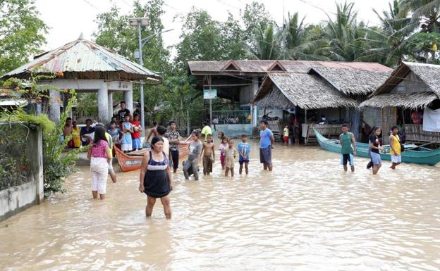 Varias personas tratan de ayudar a víctimas de las inundaciones.