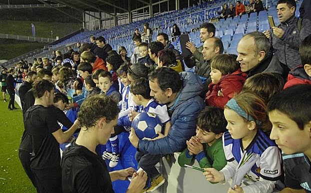 Los jugadores de la Real firman autógrafos en Zubieta.