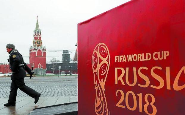 Un oficial del Ministerio de Interior ruso pasa junto a un cartel de la Copa del Mundo frente al palacio del Kremlin. 