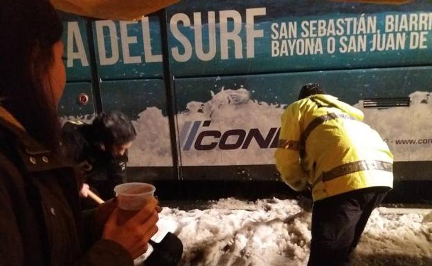 Un trabajador retira la nieve que bloqueba el avance de un autobús el domingo en Etzegarate. 