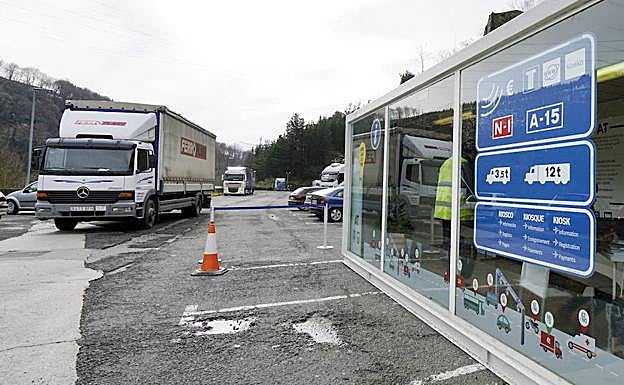 Imagen principal - Una de las oficinas en las que se puede abonar el peaje y dos camioneros consultando las tarifas.