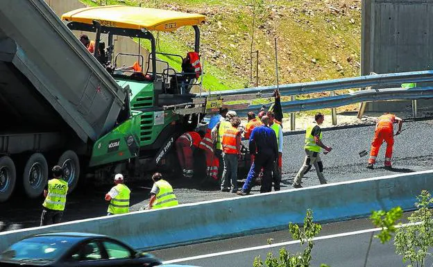 Varios operarios desarrollan tareas de asfaltado en la autopista.