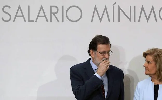 Rajoy (i) y Fátima Báñez hablan antes de la firma del acuerdo social para la subida del salario mínimo interprofesional. 