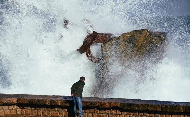 Una persona observa las olas en el Peine del Viento. 