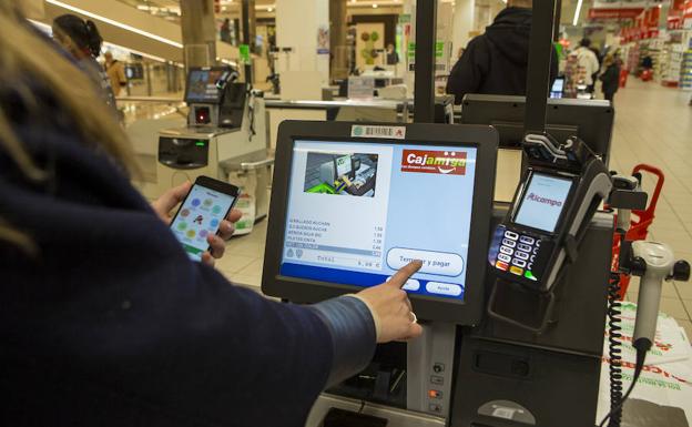 Una mujer emplea una aplicación de compras en un supermercado. 