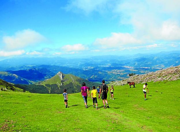 Un grupo de personas camina por los alrededores del Txindoki. 