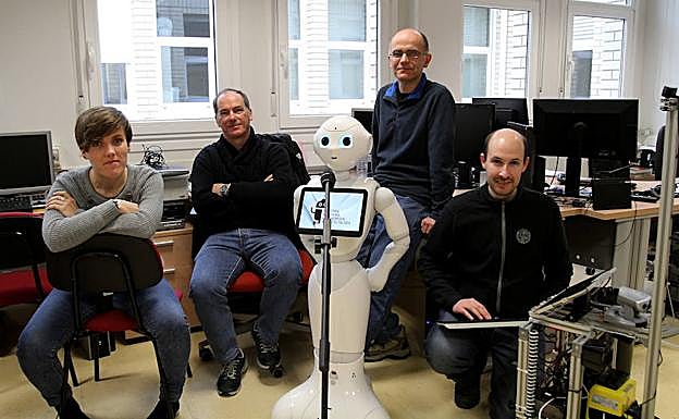 Ezkerretik eskuinera, Izaro Goienetxea, Basilio Sierra, José Maria Martínez-Otzeta eta Iñigo Mendialua ikertzaileak. Eta robota, jakina.