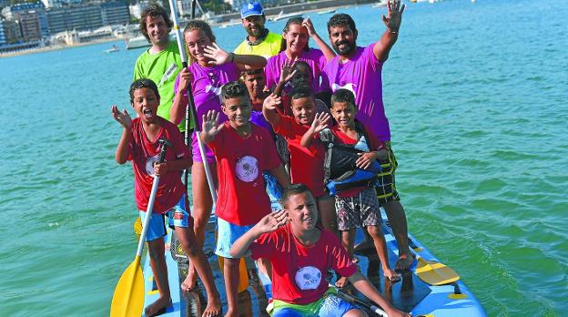 Niños saharauis se divierten haciendo 'stand up paddle' junto a varios monitores.