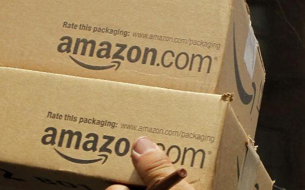 Un trabajador de Amazon lleva varios paquetes solicitados por clientes. 