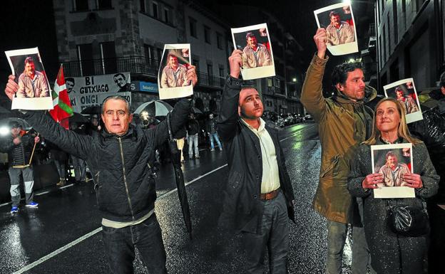 Víctimas de ETA y miembros del PP, con fotos de 'Pagaza', se plantaron el domingo frente al recibimiento a los dos expresos. 