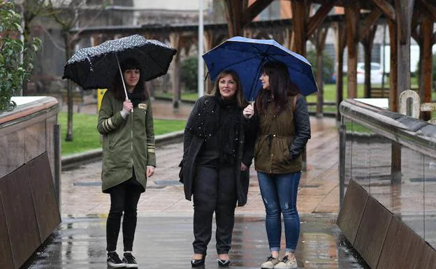 La viuda y las dos hijas de Isaías Carrasco pasean por las calles de Arrasate en una mañana lluviosa. 