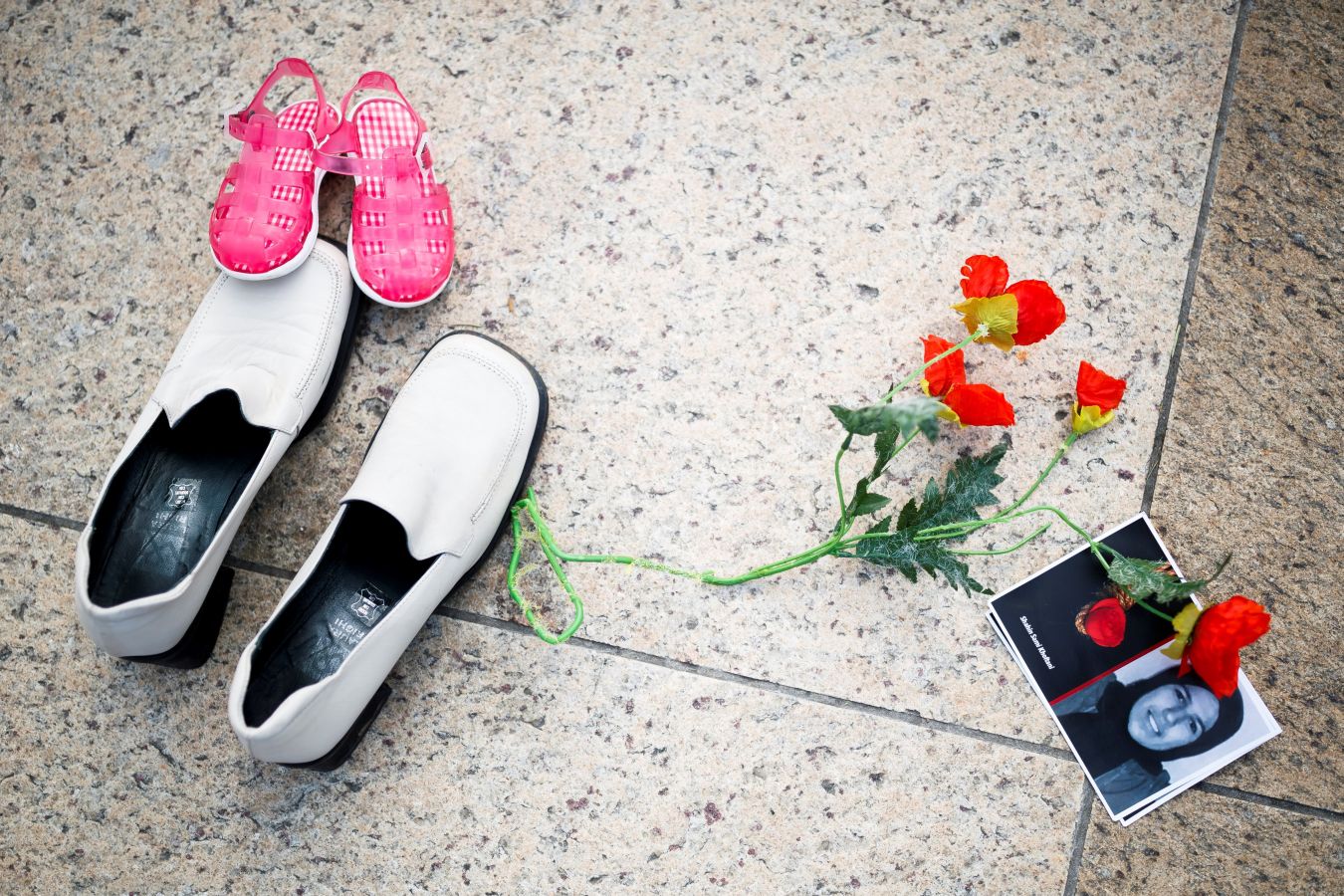 Un grupo de personas protestan con zapatos y flores en las inmediaciones de la sede de la ONU en Ginebra contra el discurso del ministro de Justicia iraní, Ali Reza Avaei, por su rol en las ejecuciones de prisioneros políticos iraníes de 1988.