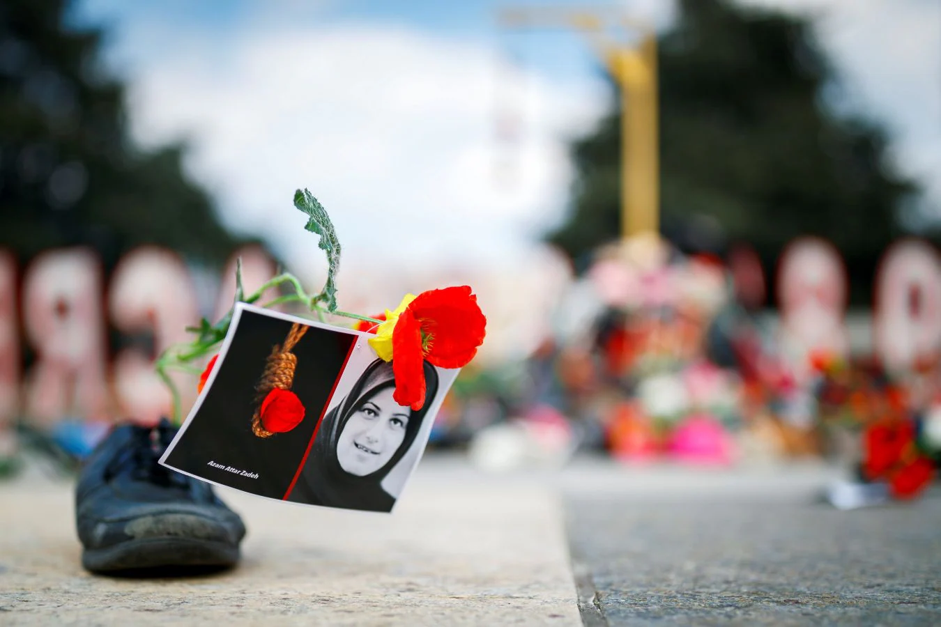 Un grupo de personas protestan con zapatos y flores en las inmediaciones de la sede de la ONU en Ginebra contra el discurso del ministro de Justicia iraní, Ali Reza Avaei, por su rol en las ejecuciones de prisioneros políticos iraníes de 1988.