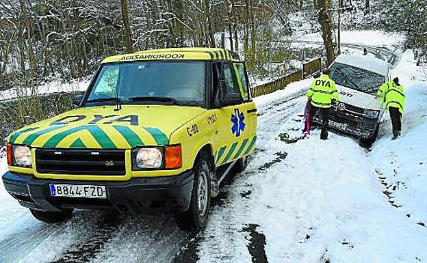 El patrol de la DYA remolca a un vehículo atrapado en el arcén en una carretera secundaria de Donostia. 