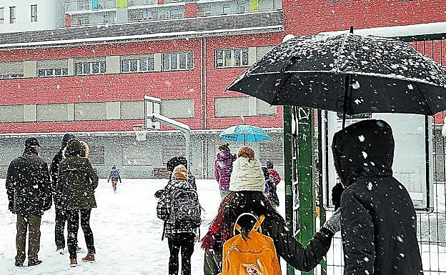 Los alumnos llegan al patio de su ikastola en San Sebastián, cubierta de nieve, dispuestos a disfrutar. 