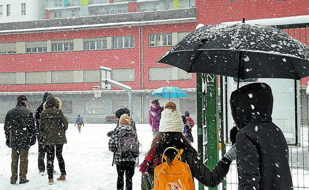 Los alumnos llegan al patio de su ikastola en San Sebastián, cubierta de nieve, dispuestos a disfrutar. 
