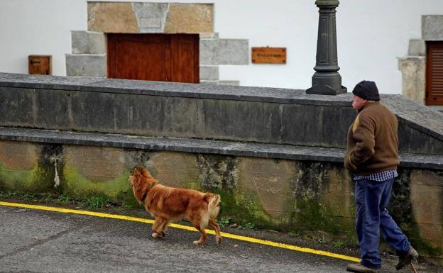 Un vecino de Orexa camino junto a su can.