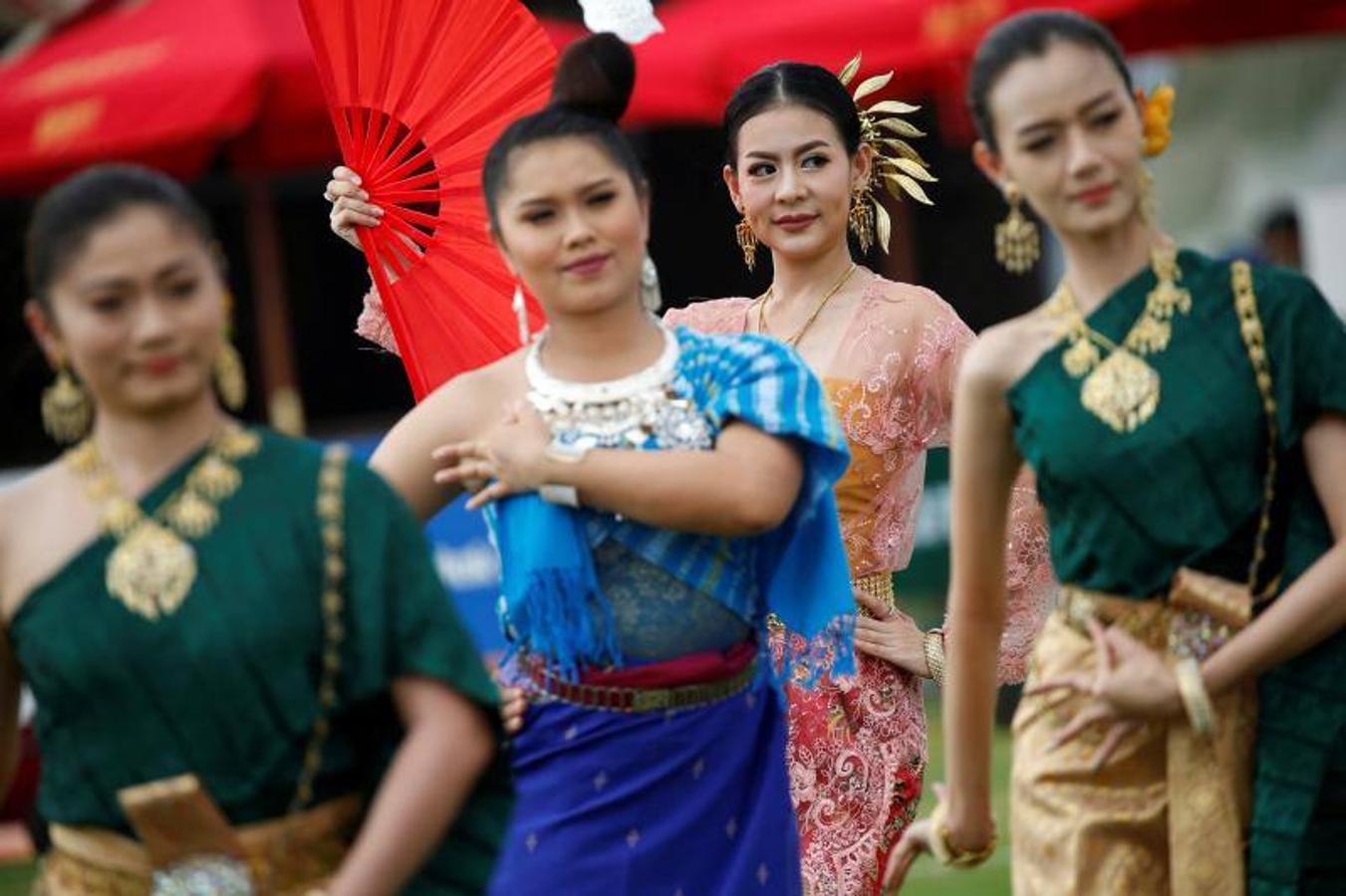 La gente alimenta a los elefantes antes de un partido en el Torneo de Polo de Elefante de la Copa del Rey en un resort ribereño en Bangkok