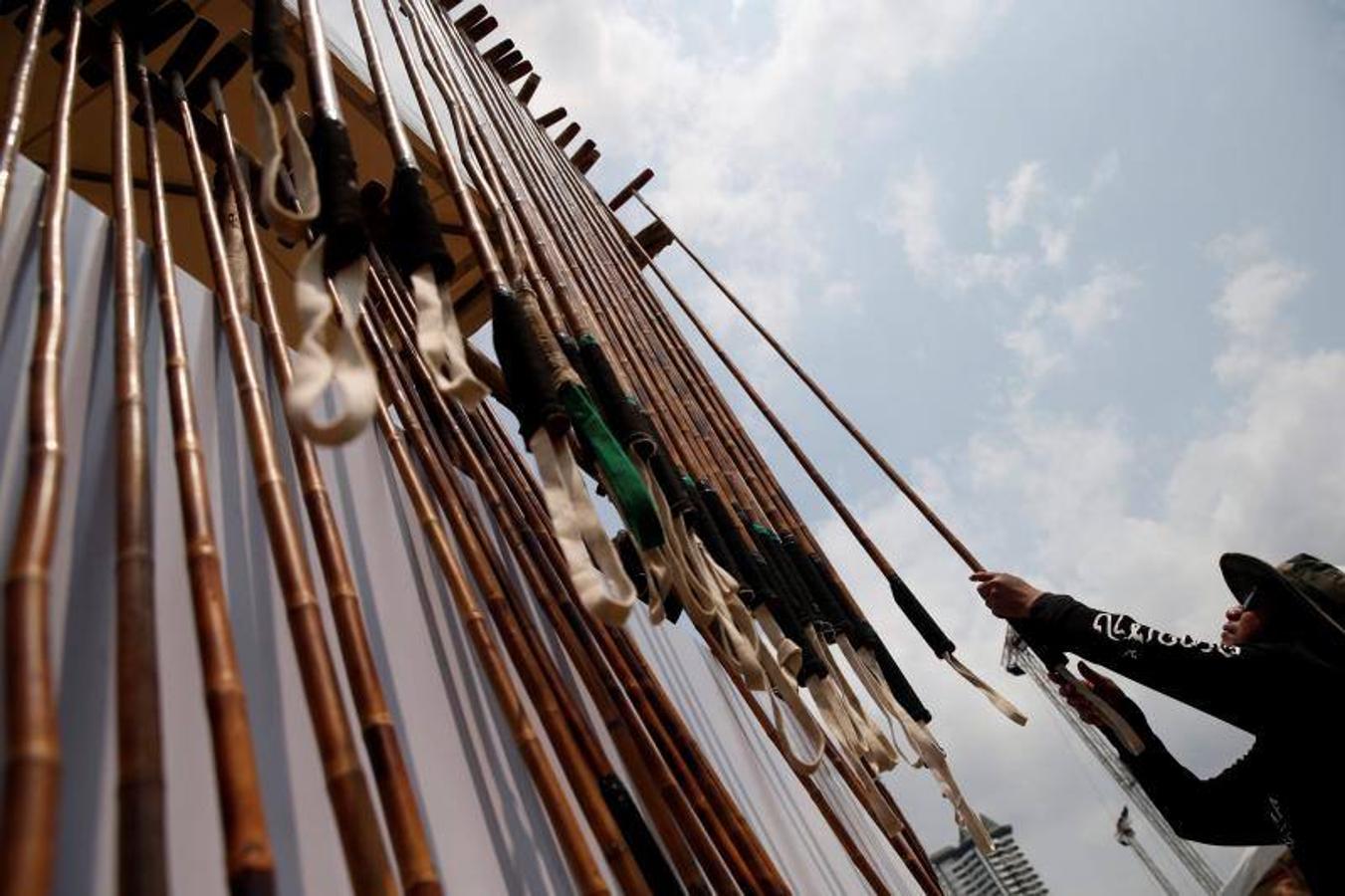 La gente alimenta a los elefantes antes de un partido en el Torneo de Polo de Elefante de la Copa del Rey en un resort ribereño en Bangkok