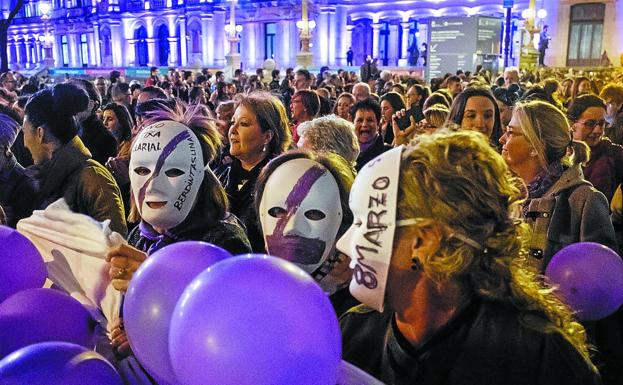 Mujeres con caretas y globos morados participan en la manifestación que anoche recorrió las calles de Donostia. 