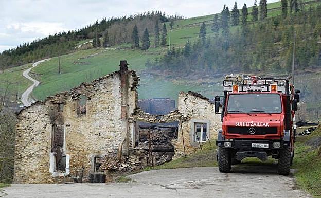 Un camión de los bomberos en el caserío calcinado
