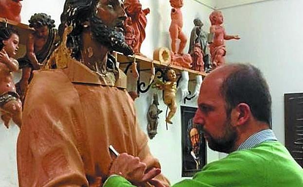 El escultor Alberto Pérez Rojas restaurando la talla de Jesús.