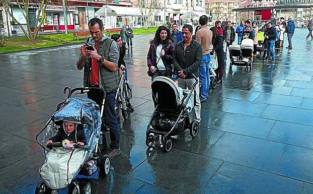 Los bebés y sus aitas y amas hicieron cola frente al Ayuntamiento para recibir sus acebos. 