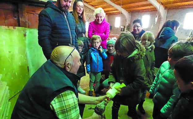 Juan Joxe ayudando a los niños a alimentar a los corderos.
