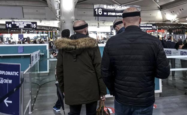 Tres jóvenes en el control de Policía del aeropuerto de Estambul, de regreso a su casa, tras someterse a un trasplante de pelo. 