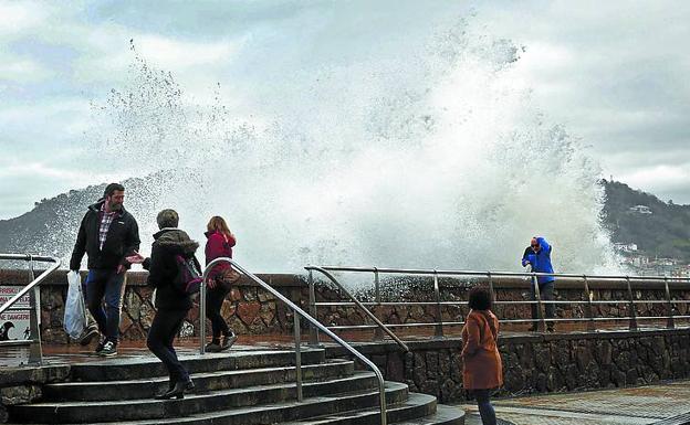 Una ola sorprende a algunos paseantes en el Paseo Nuevo de San Sebastián. 