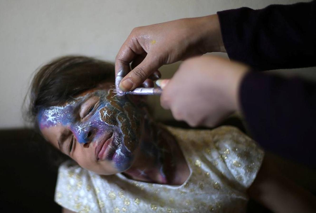 Alaa Abu Mustafa muestra su destreza con el maquillaje pintando la cara a los niños palestinos al sur de la Franja de Gaza. 