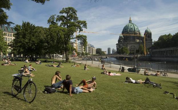 Berlineses toman en sol en un parque de la ciudad.