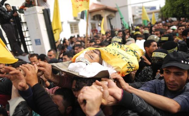 Palestinos llevan el cuerpo de uno de los fallecidos en la marcha organizada con ocasión del Día de la Tierra. / AFP
