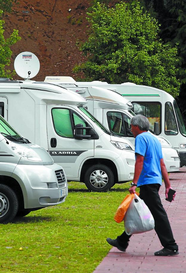 Un usuario se acerca a una de las caravanas aparcadas en Berio.